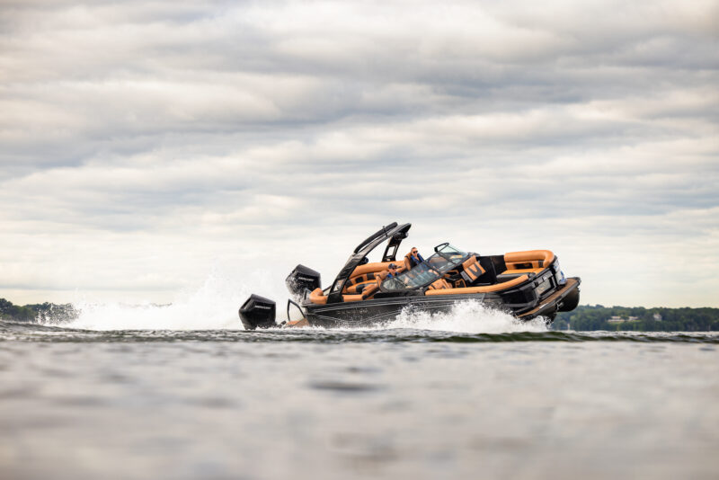 Premier Intrigue GTS luxury performance pontoon cornering at high speed across open water.