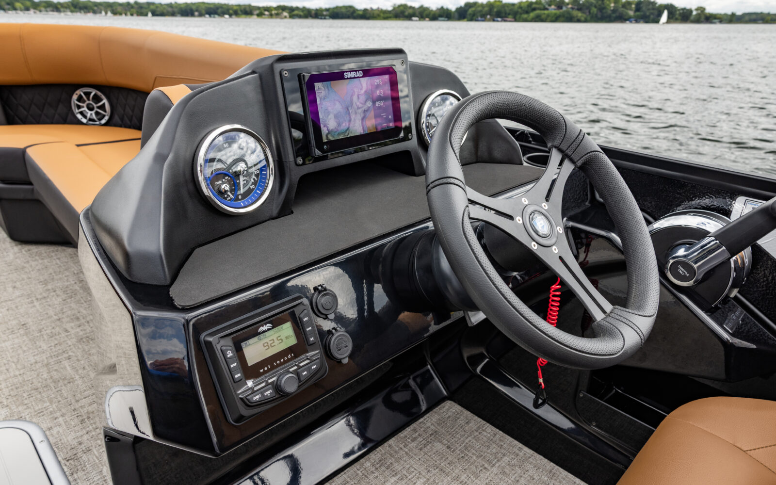 Premier Sunscape pontoon helm with Simrad touchscreen display, gauges, and premium steering wheel.