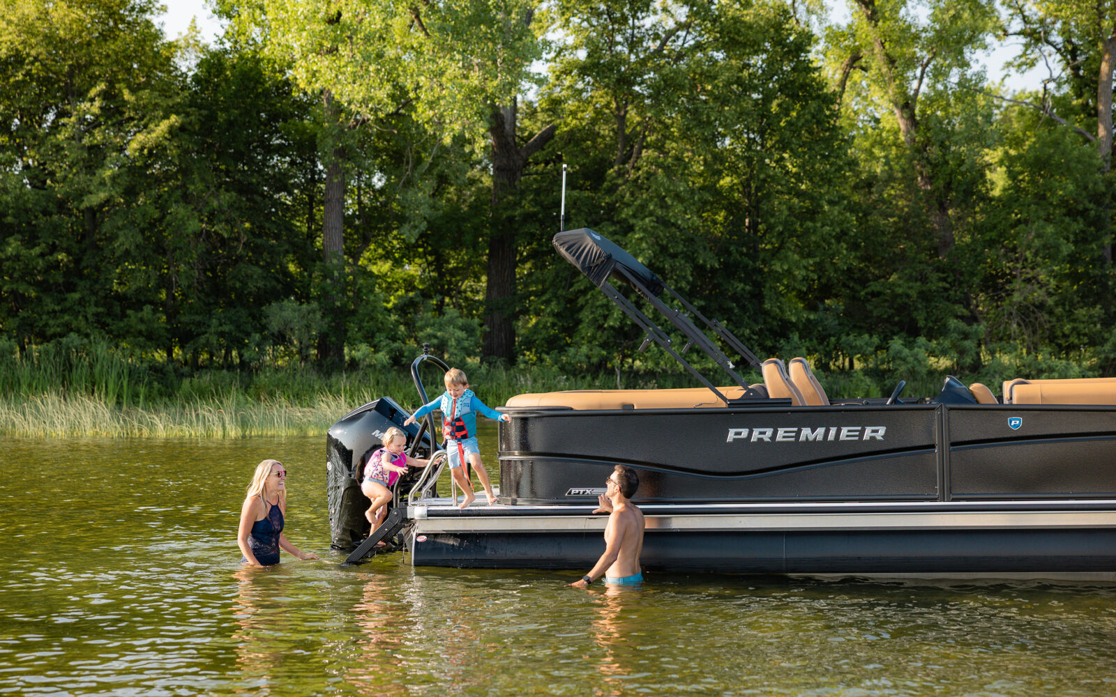 Family enjoying the swim platform on a Premier Sunscape pontoon boat.