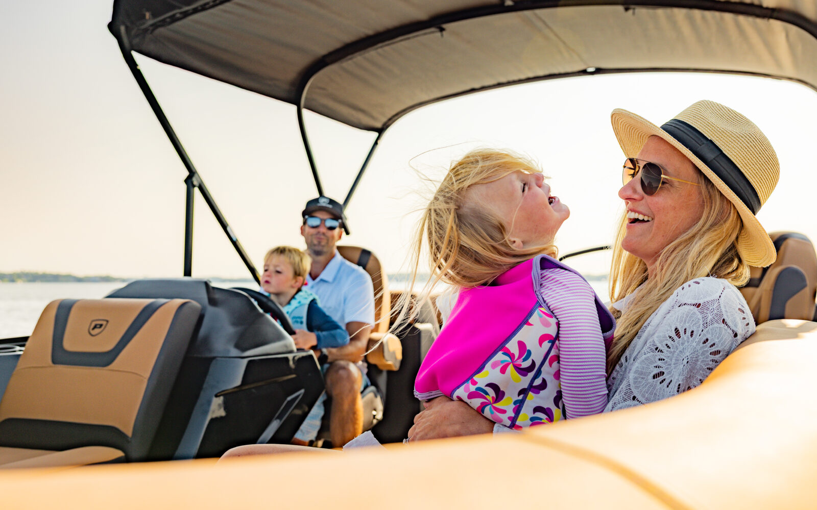 Family enjoying a day on the water aboard a Premier Sunscape pontoon boat.