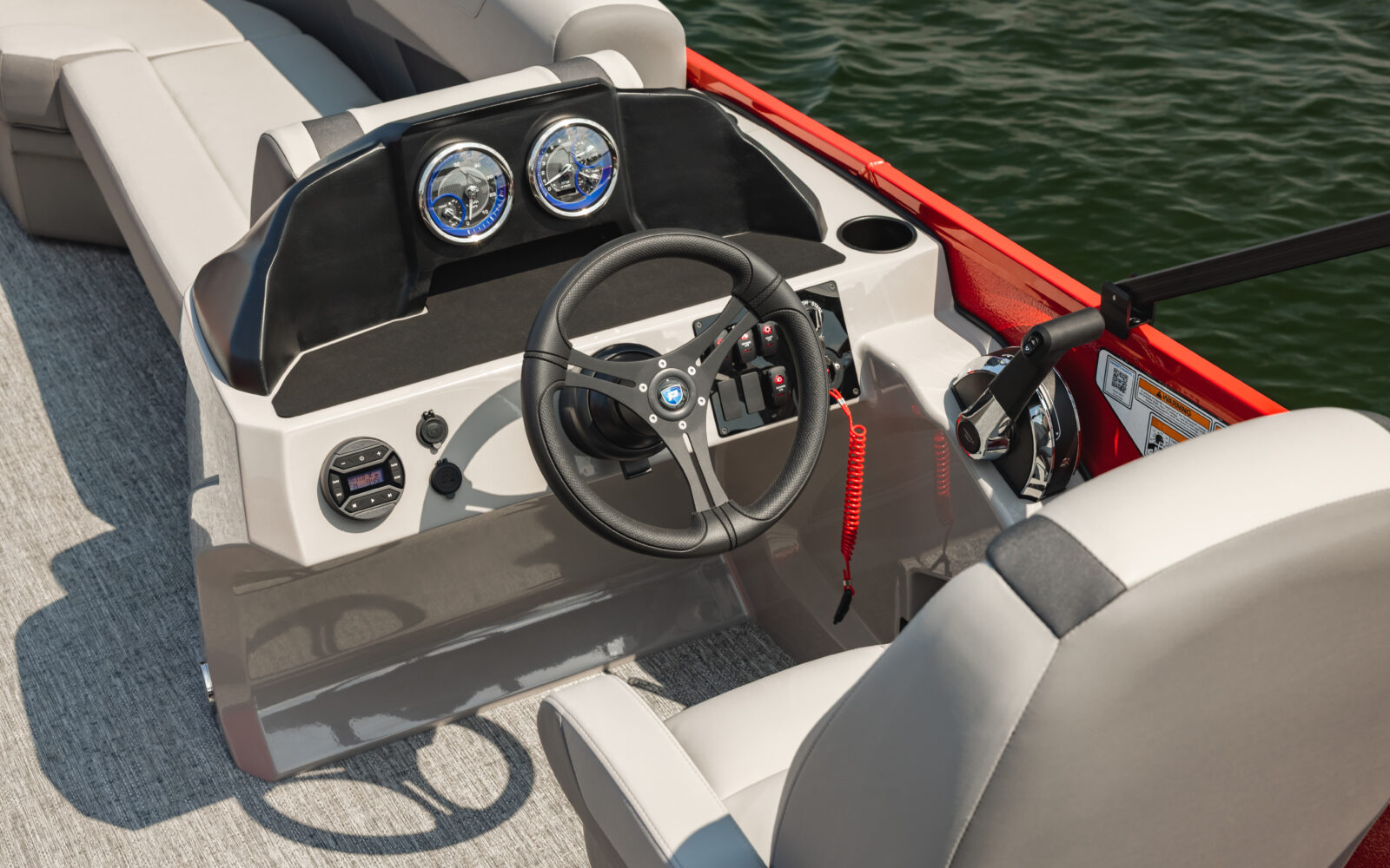 Premier Sunscape pontoon helm with gauges, steering wheel, and premium captain's chair.
